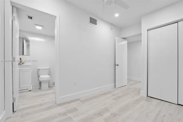 wooden floor in an empty room with a bathroom