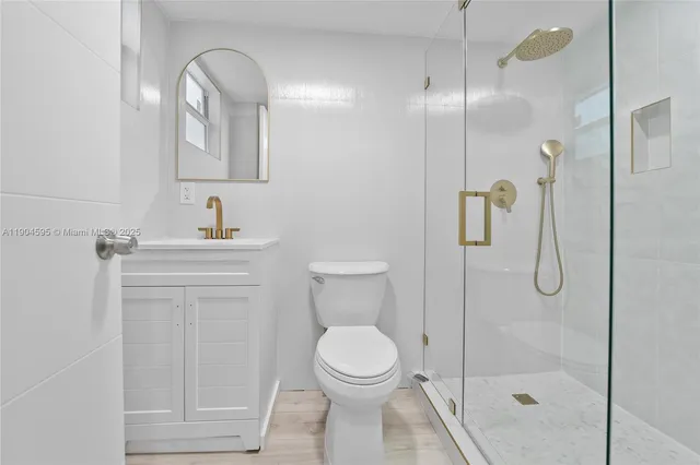 a bathroom with a toilet sink vanity and shower