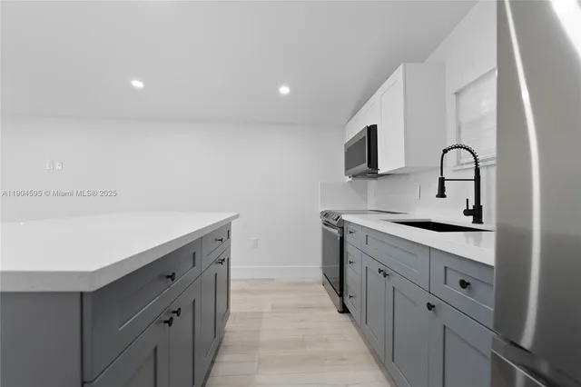 a kitchen with granite countertop a sink and cabinets