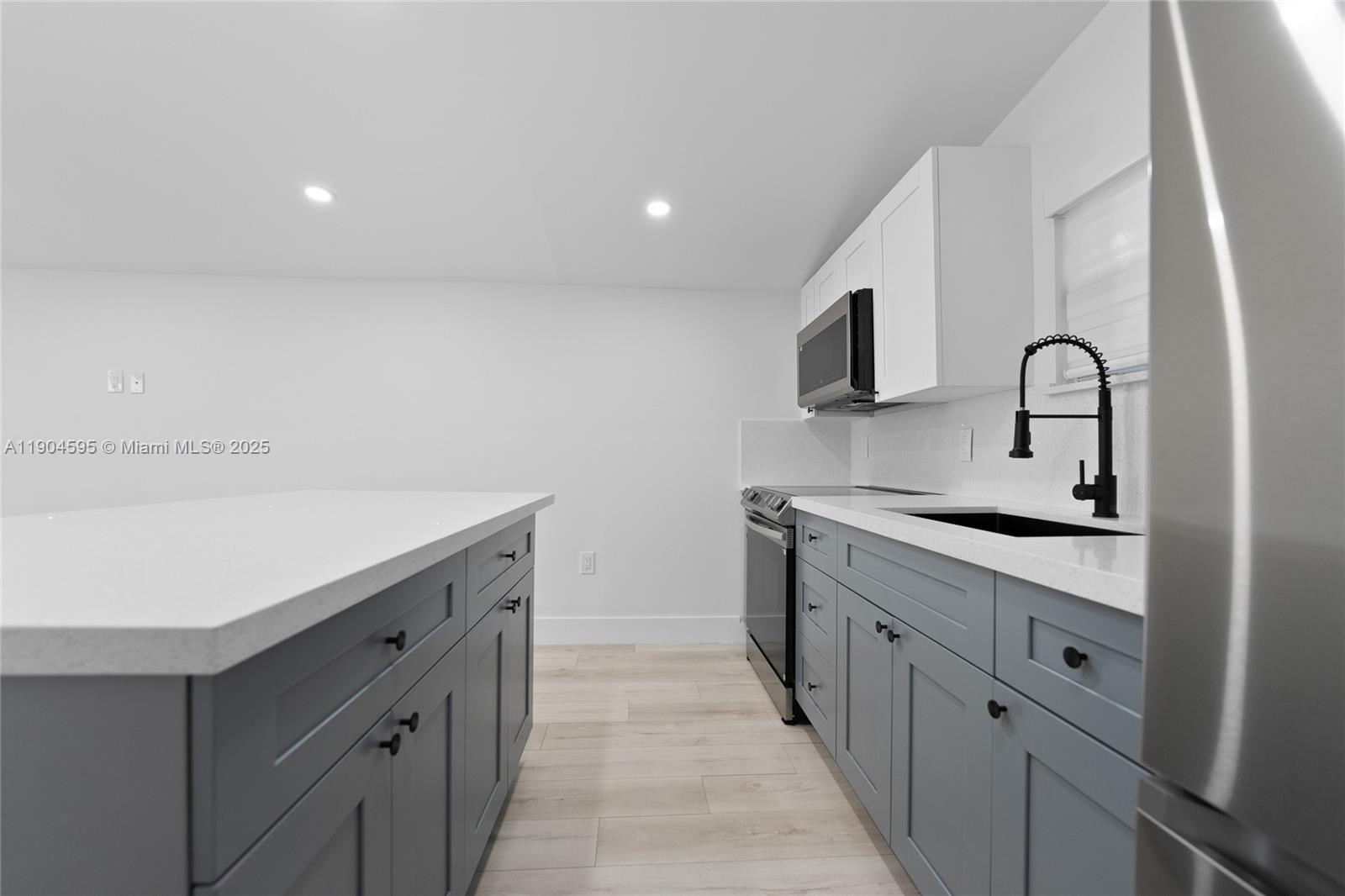129 Southwest 9th Avenue, Unit 2 Miami, FL 33130 - Photo 5 of 16 a kitchen with granite countertop a sink and cabinets