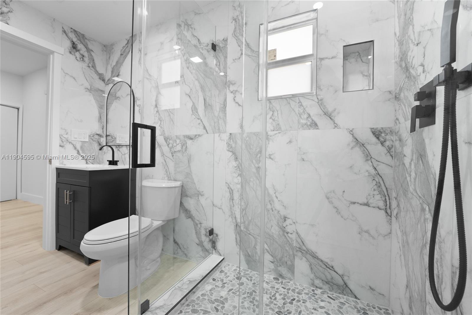 129 Southwest 9th Avenue, Unit 2 Miami, FL 33130 - Photo 8 of 16 a bathroom with a granite countertop sink a toilet and a shower