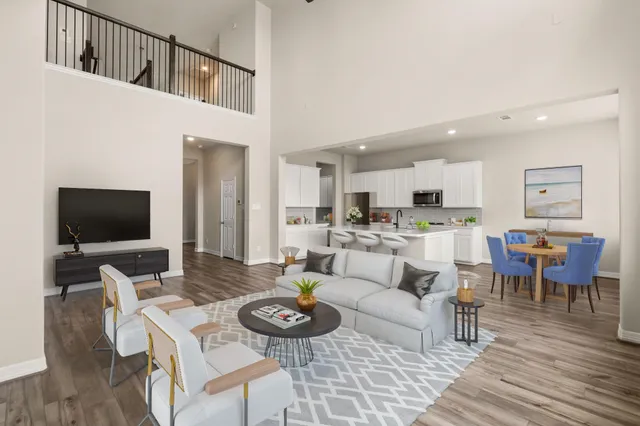 a living room with furniture kitchen view and a flat screen tv