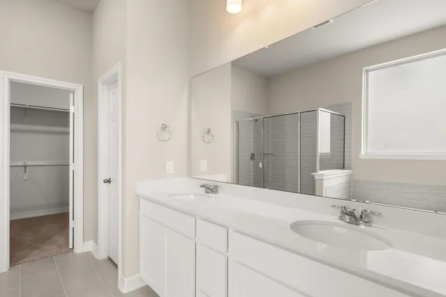 a bathroom with a double vanity sink and a mirror