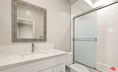 a bathroom with a sink toilet vanity and shower