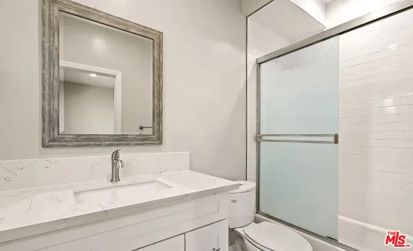 a bathroom with a sink toilet vanity and shower