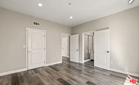 a view of an empty room with wooden floor
