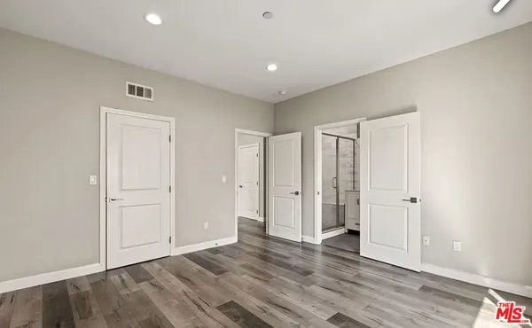 a view of an empty room with wooden floor