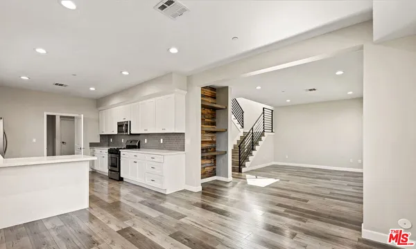 a view of a kitchen with a sink wooden floor and a window