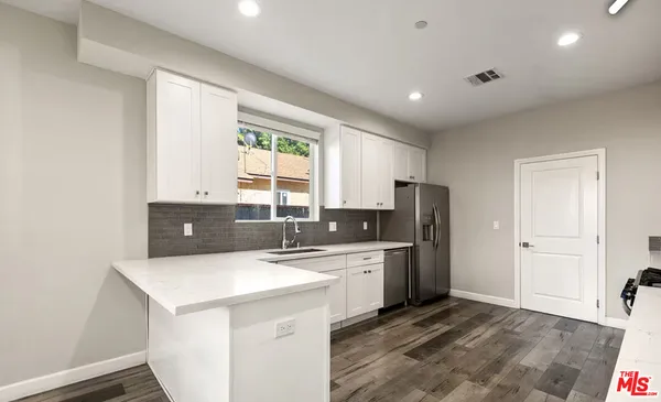 a kitchen with stainless steel appliances a sink stove and refrigerator