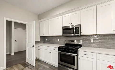 a kitchen with white cabinets and stainless steel appliances
