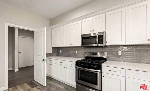 a kitchen with white cabinets and stainless steel appliances
