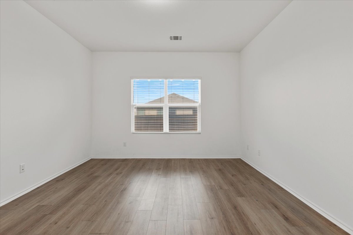 101 Rowdy Yates Way Jarrell, TX 76537 - Photo 14 of 32 Bright interior room featuring wood-finish flooring, crisp white walls, and a window with horizontal blinds