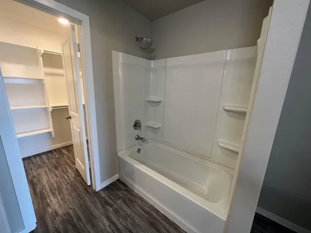 a bathroom with a tub shower and a sink