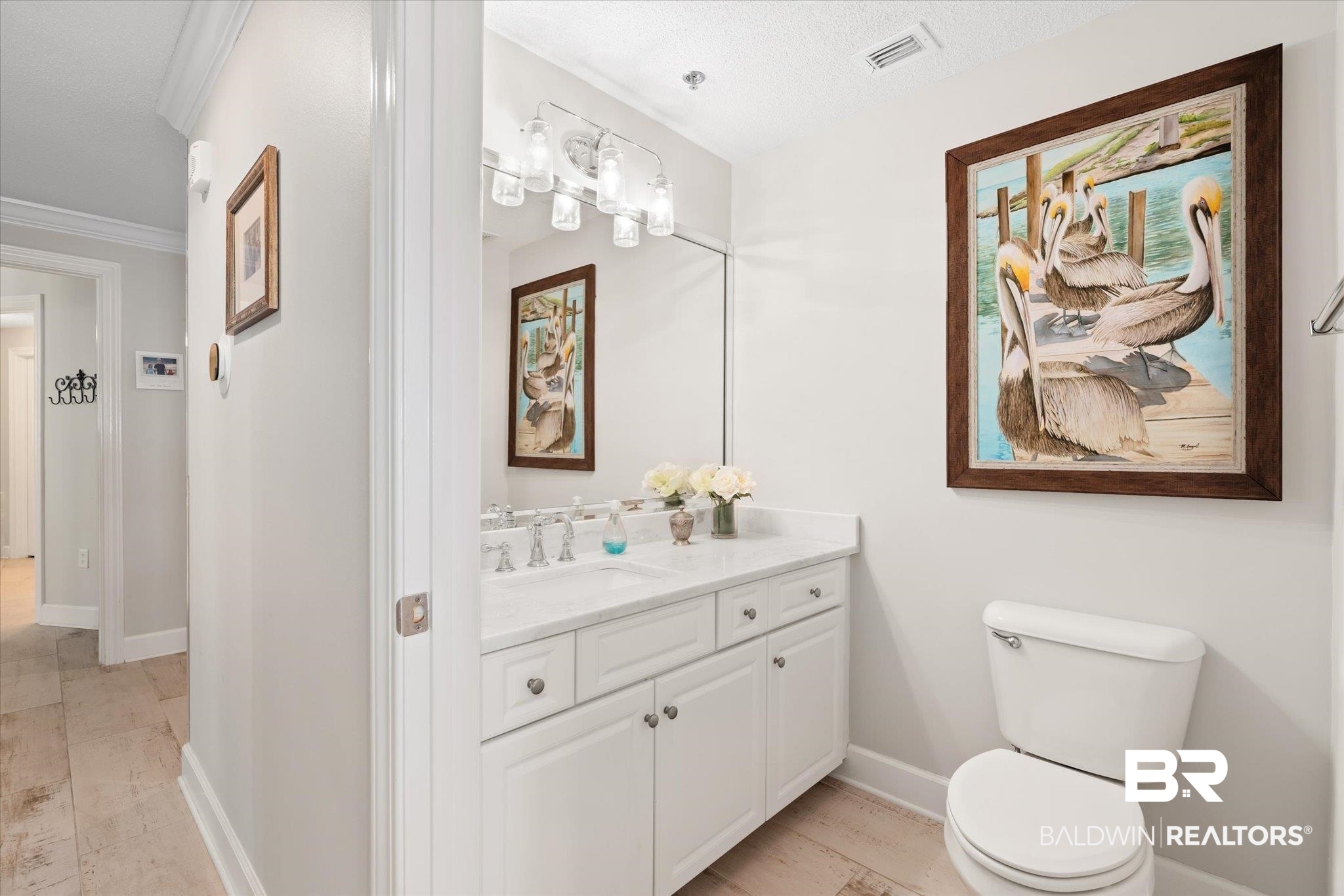 27582 Canal Road, Unit 2611 Orange Beach, AL 36561 - Photo 26 of 37 Bathroom with a textured ceiling, hardwood / wood-style floors, ornamental molding, vanity, and toilet