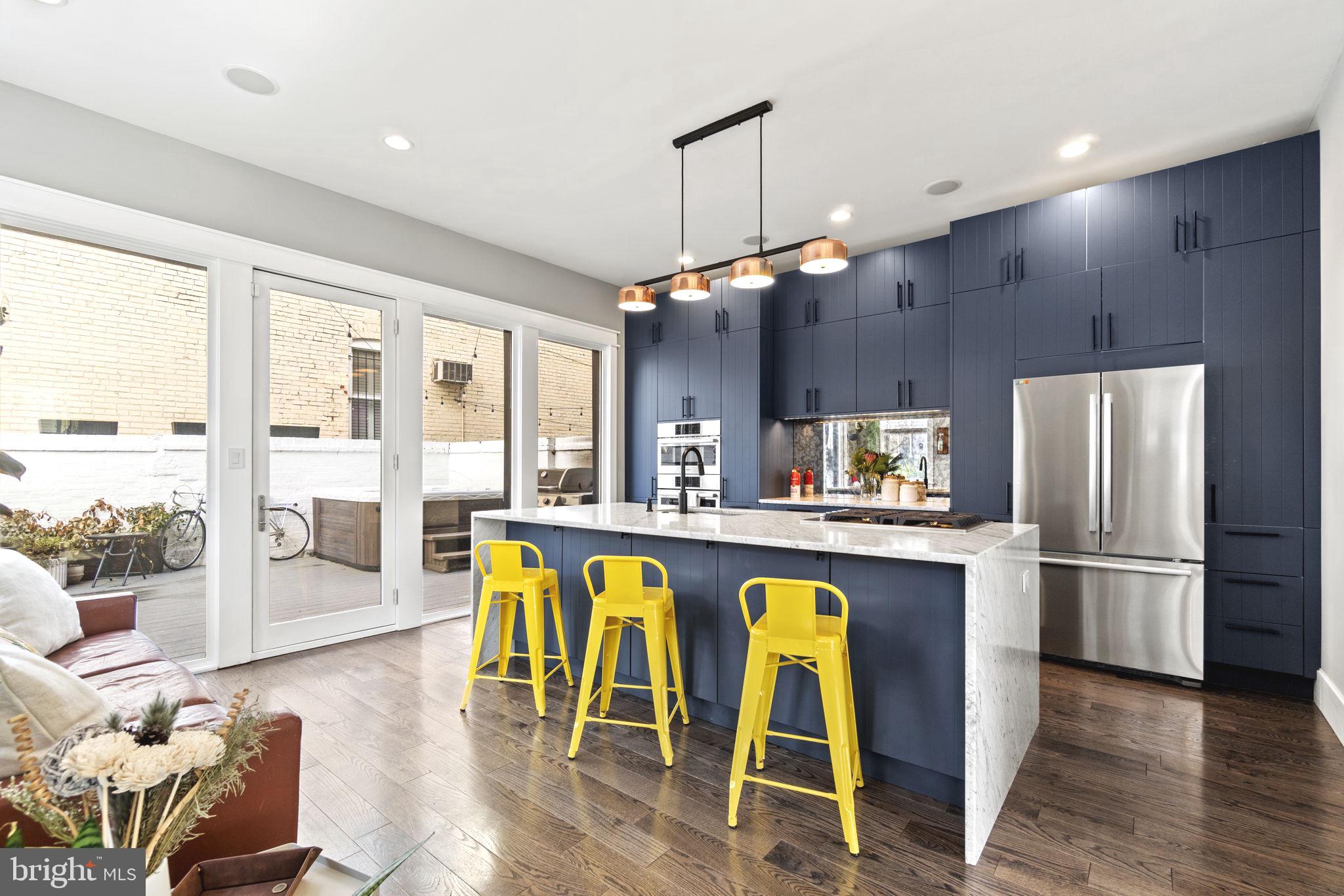 85 R Street Northwest Washington, DC 20001 - Photo 8 of 29 a kitchen with stainless steel appliances granite countertop a refrigerator a sink dishwasher a dining table and chairs with wooden floor