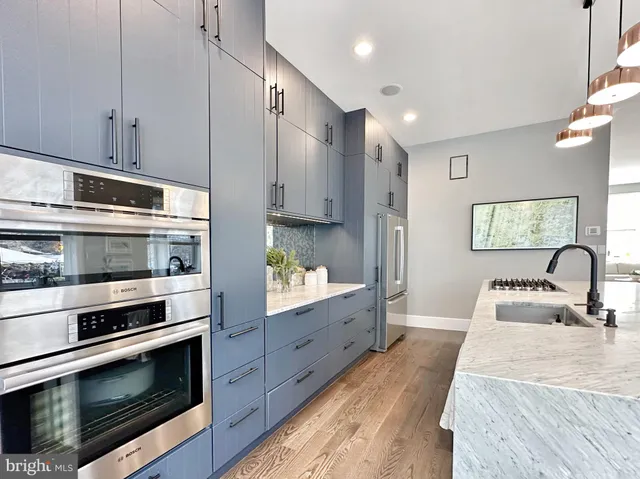 a kitchen with stainless steel appliances granite countertop a stove a sink and a refrigerator