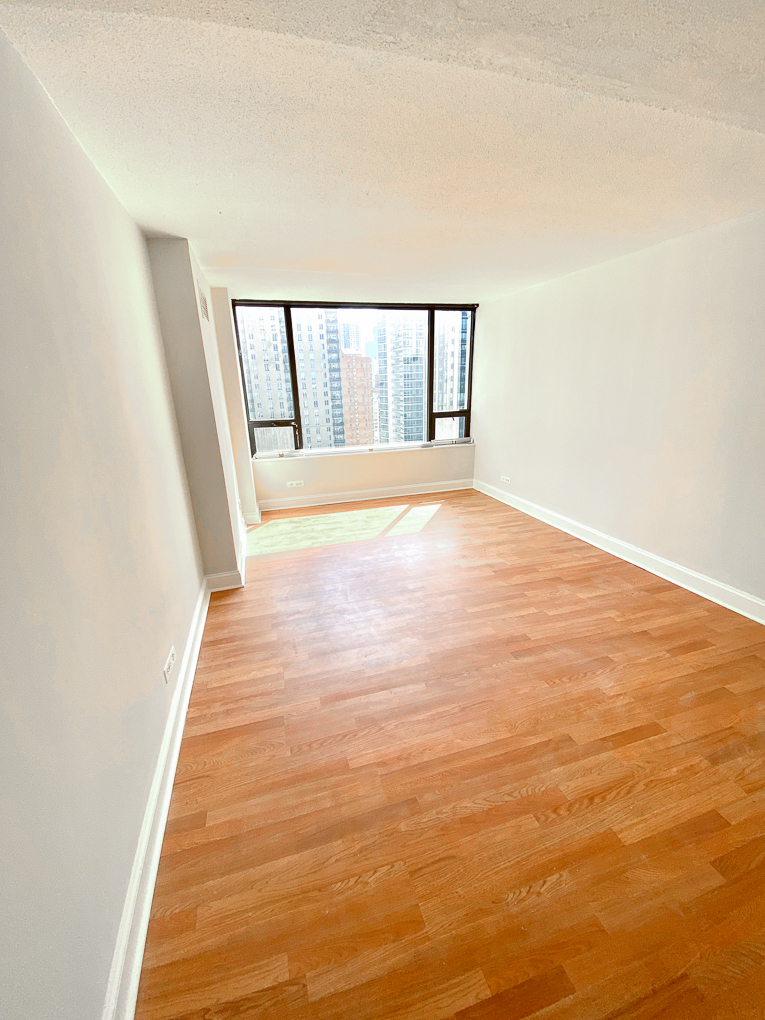 Undisclosed Address Chicago, IL 60611 - Photo 7 of 9 a view of an empty room with wooden floor and a window