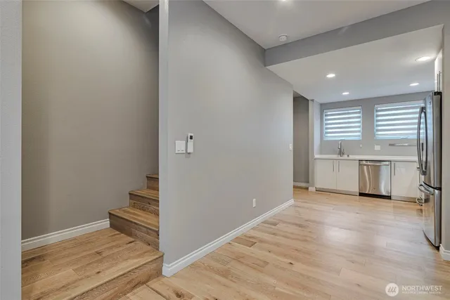 a view of a kitchen with white cabinets and wooden floor