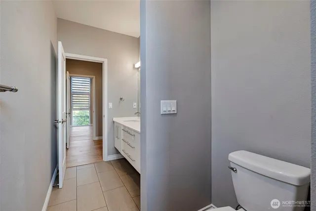 a bathroom with a granite countertop toilet and a sink