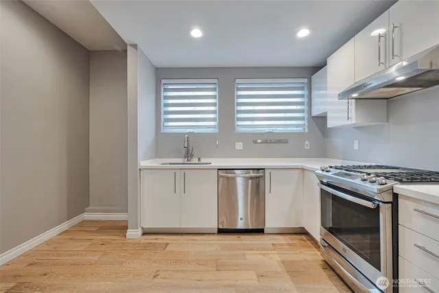 a kitchen with granite countertop a stove a sink and a microwave
