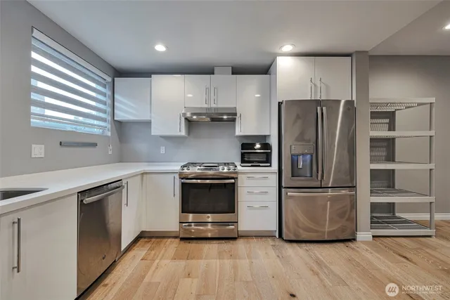 a kitchen with a refrigerator cabinets and wooden floor