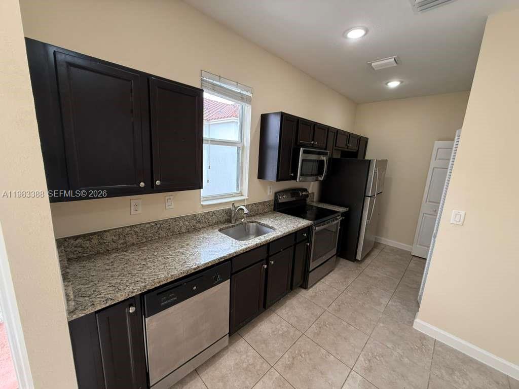 a kitchen with stainless steel appliances granite countertop a sink stove and microwave
