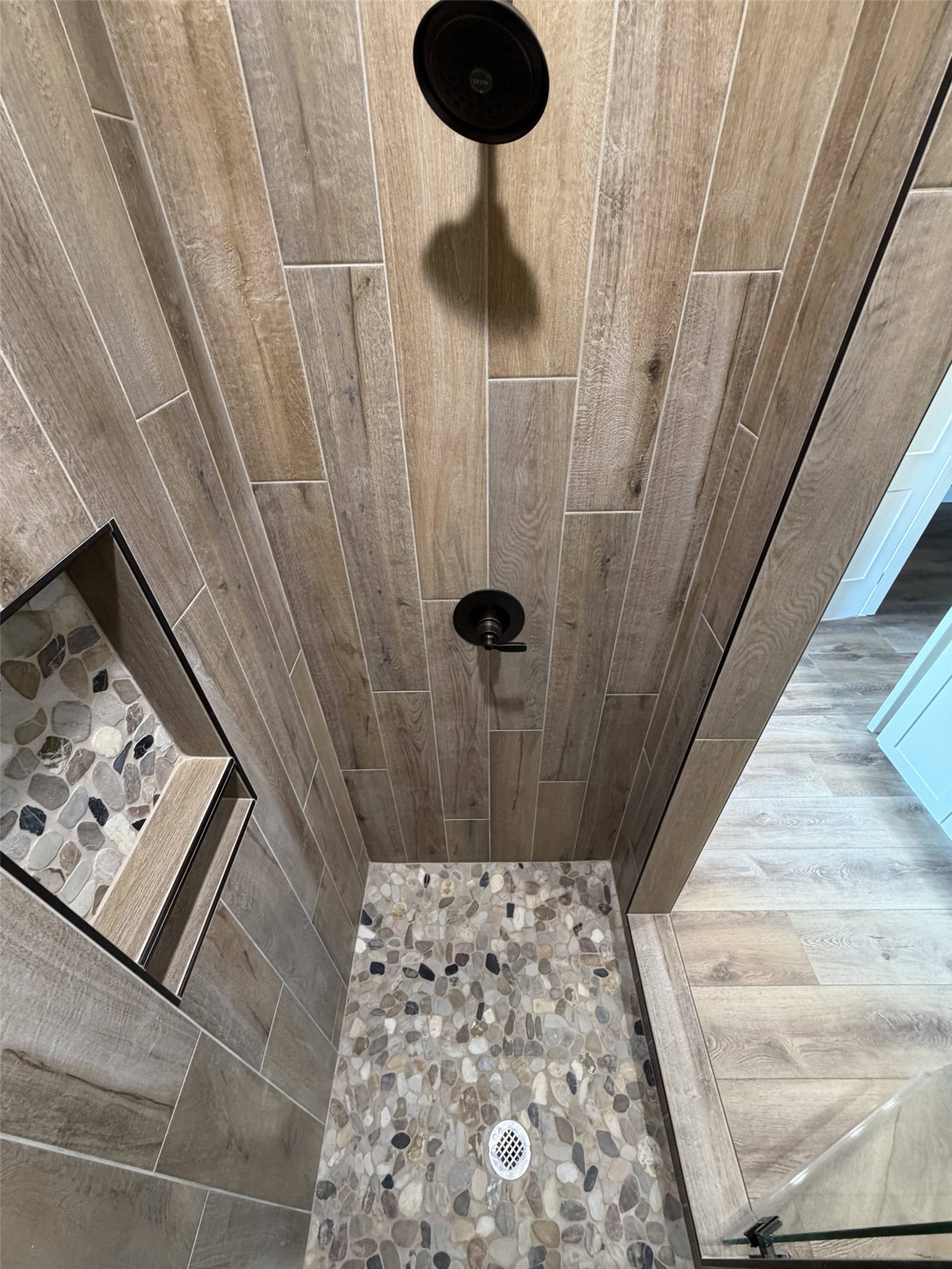 33 Wilderness Road North Calera, OK 74730 - Photo 31 of 39 Shower with wood-finish tile walls, pebble floor, and dual black showerheads