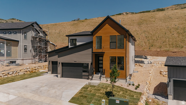 5902 Canyon Rim Road, Unit 620 Lehi, UT 84048 - Photo 3 of 78 Modern architectural home featuring a two-car garage, concrete driveway, and wood-paneled facade