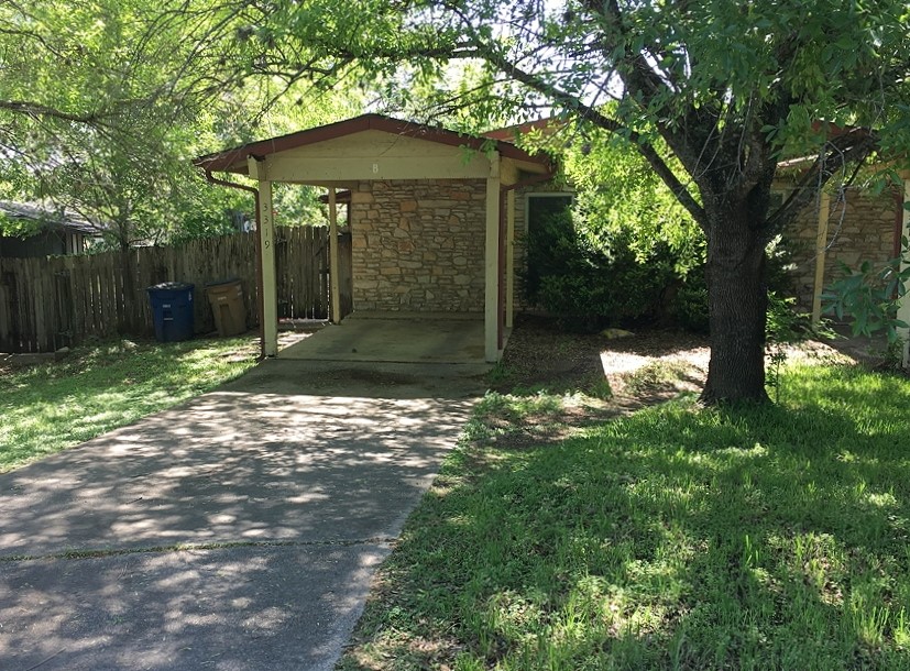 a backyard of a house with table and chairs under an umbrella
