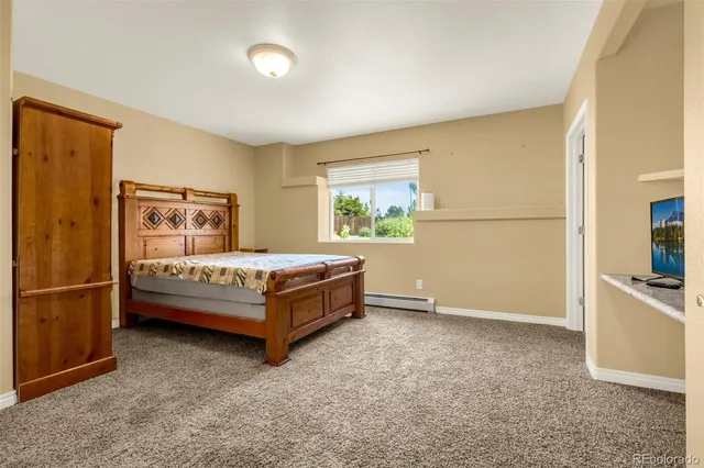 a bedroom with a bed and a refrigerator