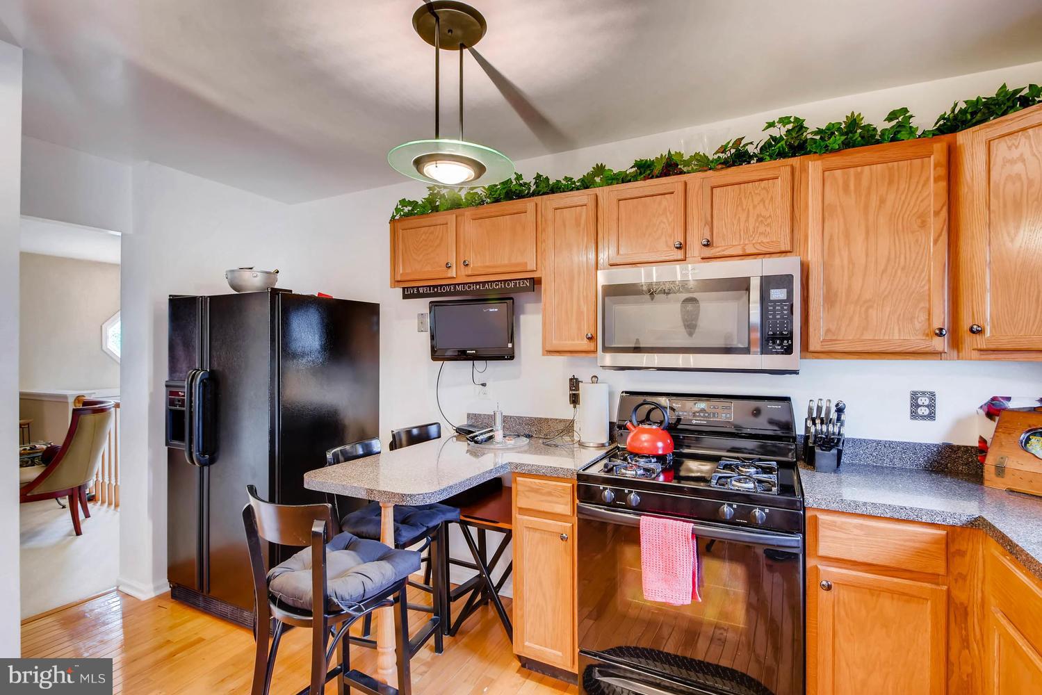 4628 Old Court Road Baltimore, MD 21208 - Photo 11 of 28 a kitchen with stainless steel appliances granite countertop a stove refrigerator and a microwave