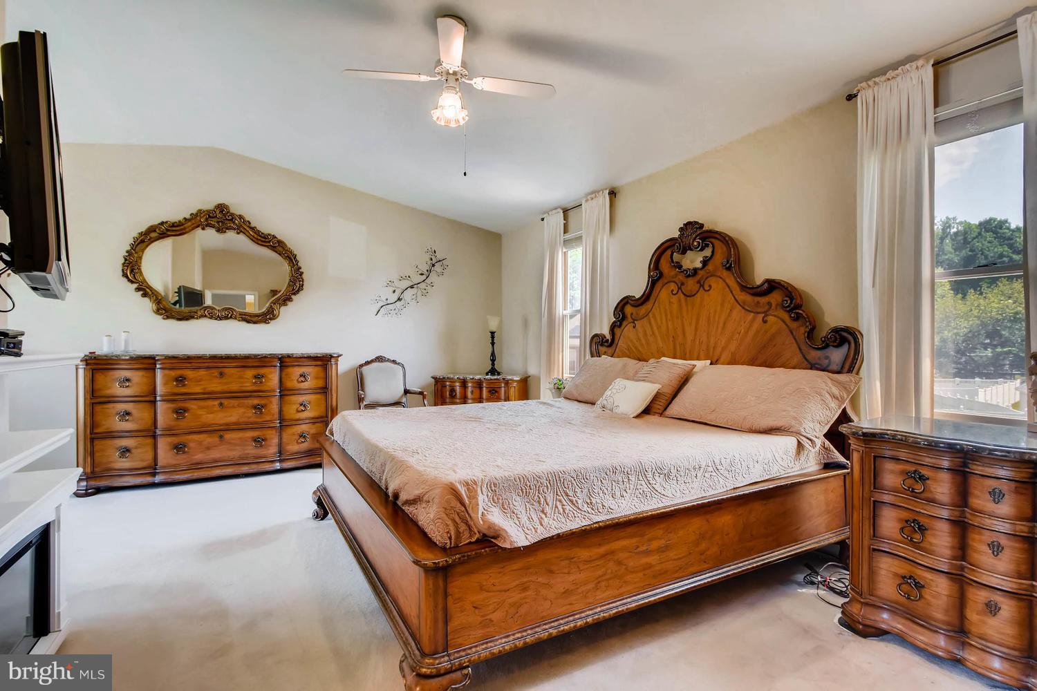 4628 Old Court Road Baltimore, MD 21208 - Photo 13 of 28 a bedroom with a bed a dresser and a chandelier