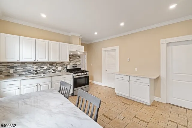 a kitchen with granite countertop a sink stove and cabinets