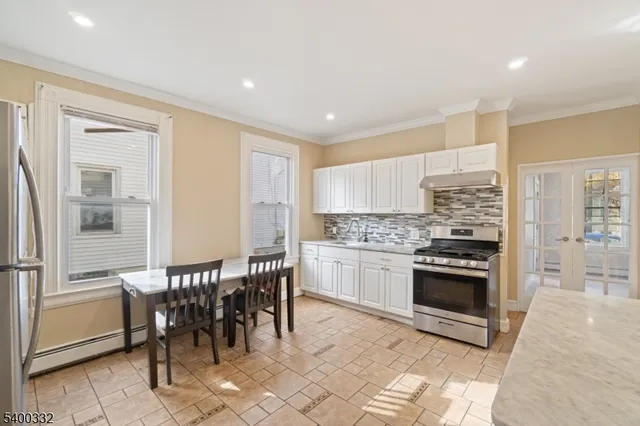 a kitchen with stainless steel appliances kitchen island granite countertop a table and chairs in it