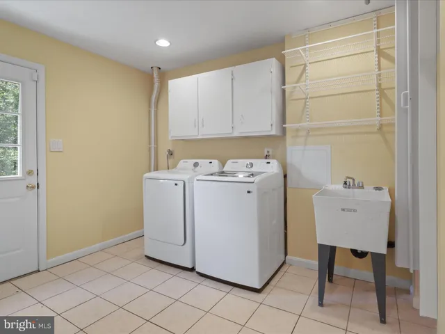 a utility room with cabinets washer and dryer