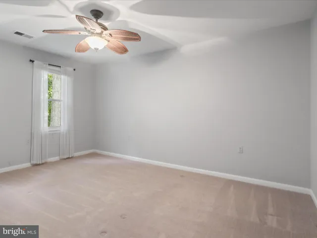 en empty room with windows and ceiling fan