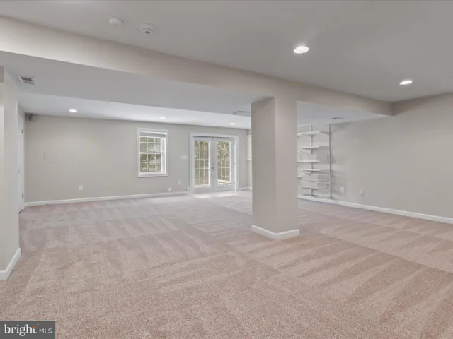 a view of an empty room with wooden floor and stairs