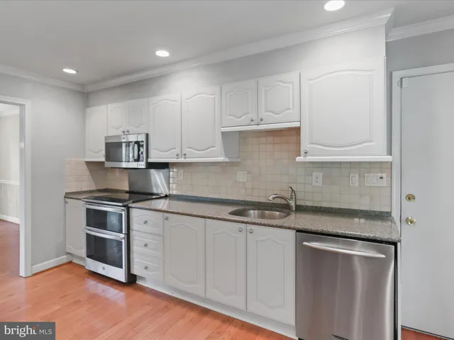 a kitchen with stainless steel appliances granite countertop a sink and cabinets