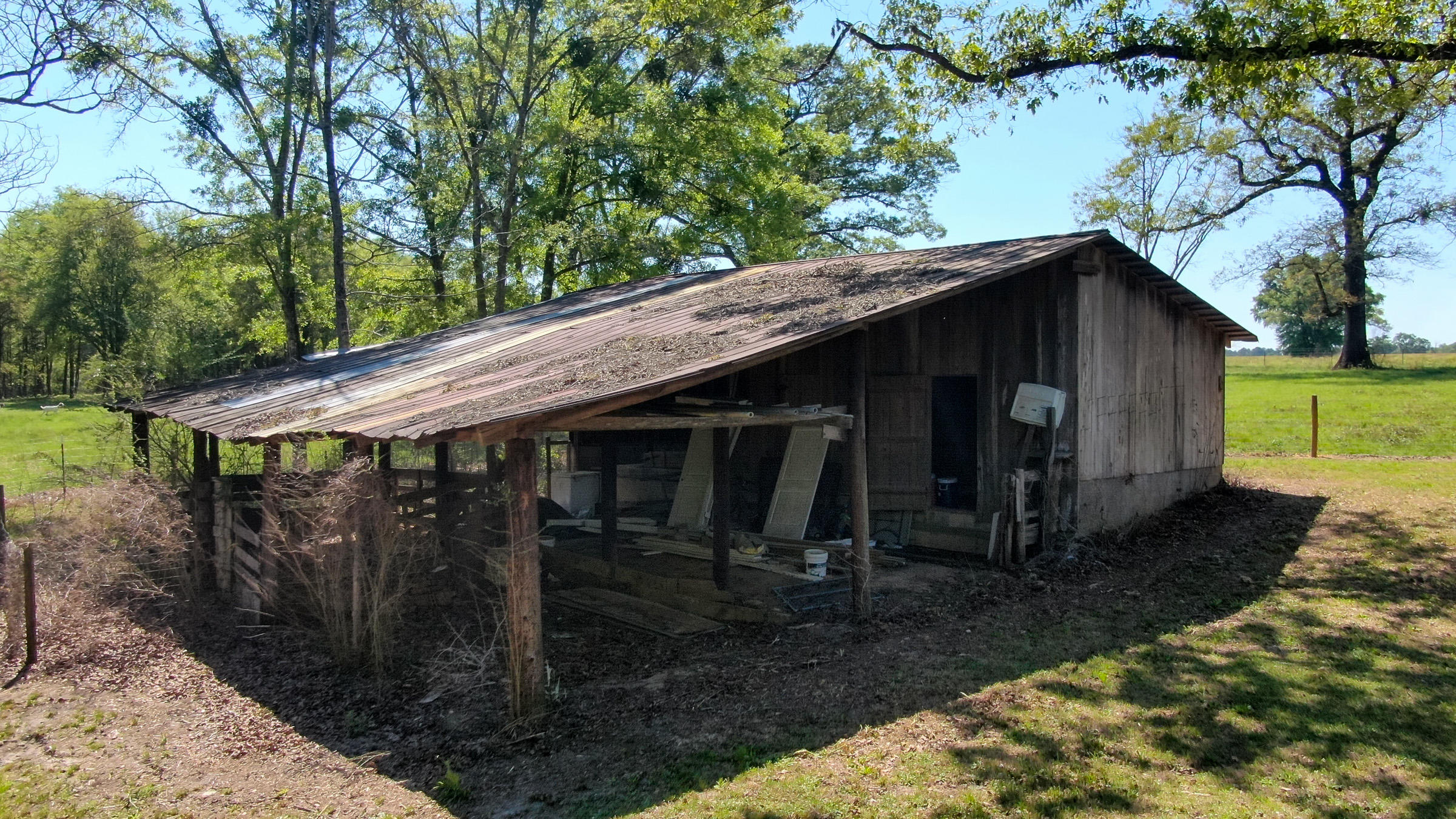 36 Williams Road DeFuniak Springs, FL 32433 - Photo 32 of 40 a barn in front of a yard with wooden fence and a large tree