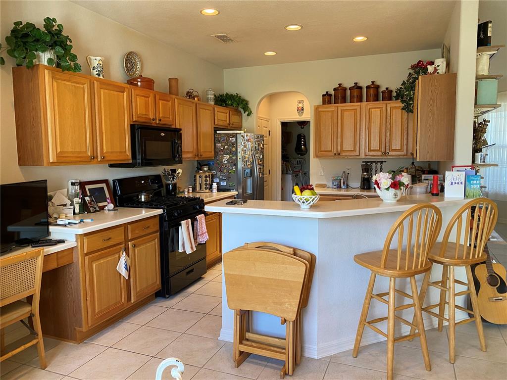 8464 Southwest 82nd Circle Ocala, FL 34481 - Photo 11 of 47 a kitchen with stainless steel appliances a sink a stove a refrigerator cabinets and a dining table with wooden floor