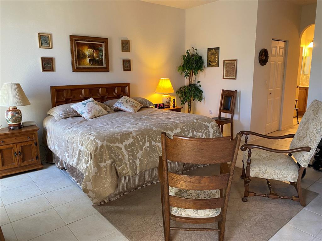 8464 Southwest 82nd Circle Ocala, FL 34481 - Photo 16 of 47 a bedroom with a bed and wooden floor
