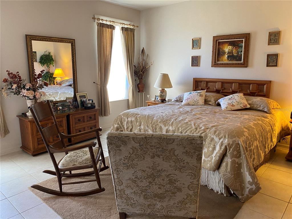 8464 Southwest 82nd Circle Ocala, FL 34481 - Photo 17 of 47 a bedroom with a bed and a dresser next to a window