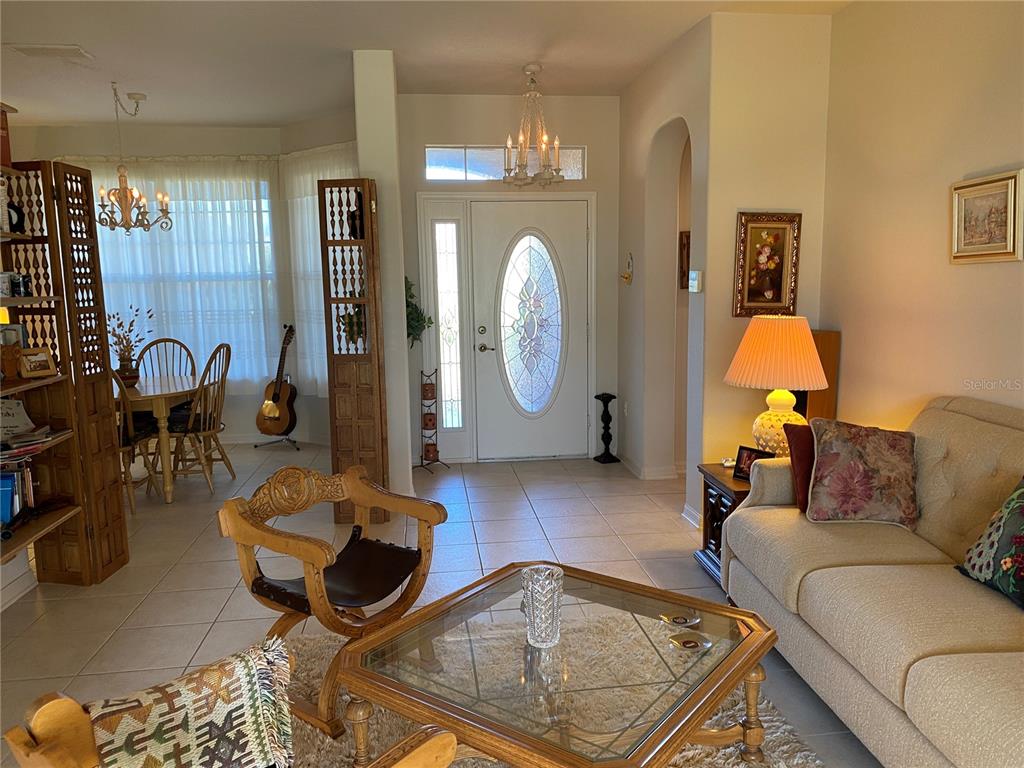 8464 Southwest 82nd Circle Ocala, FL 34481 - Photo 2 of 47 a living room with furniture a lamp and a chandelier