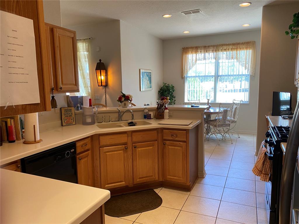 8464 Southwest 82nd Circle Ocala, FL 34481 - Photo 9 of 47 a kitchen with a sink a counter and chairs