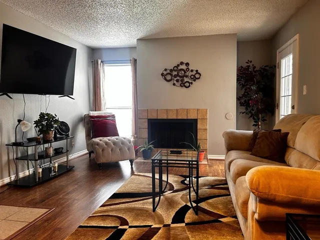 a living room with furniture a flat screen tv and a fireplace
