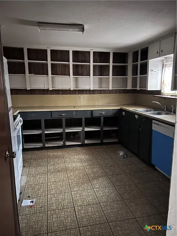 a view of an empty room with kitchen