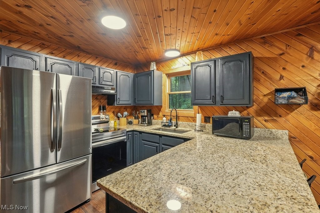6711 Booth Road Ravenna, OH 44266 - Photo 12 of 50 Kitchen featuring stainless steel appliances, gray cabinets, light stone countertops, wooden ceiling, and ventilation hood
