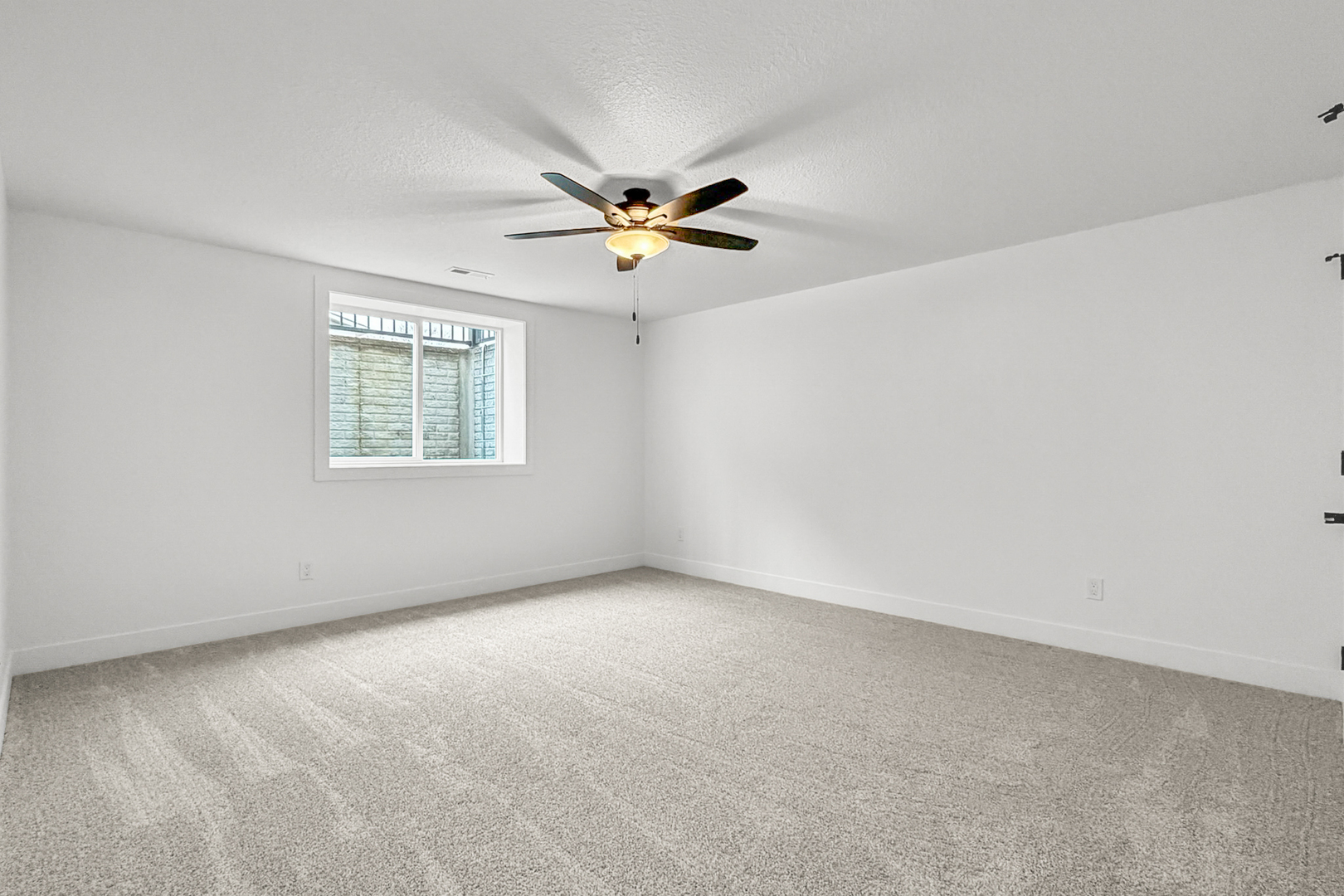 606 Kevin Road Blue Grass, IA 52726 - Photo 14 of 33 an empty room with windows and chandelier fan