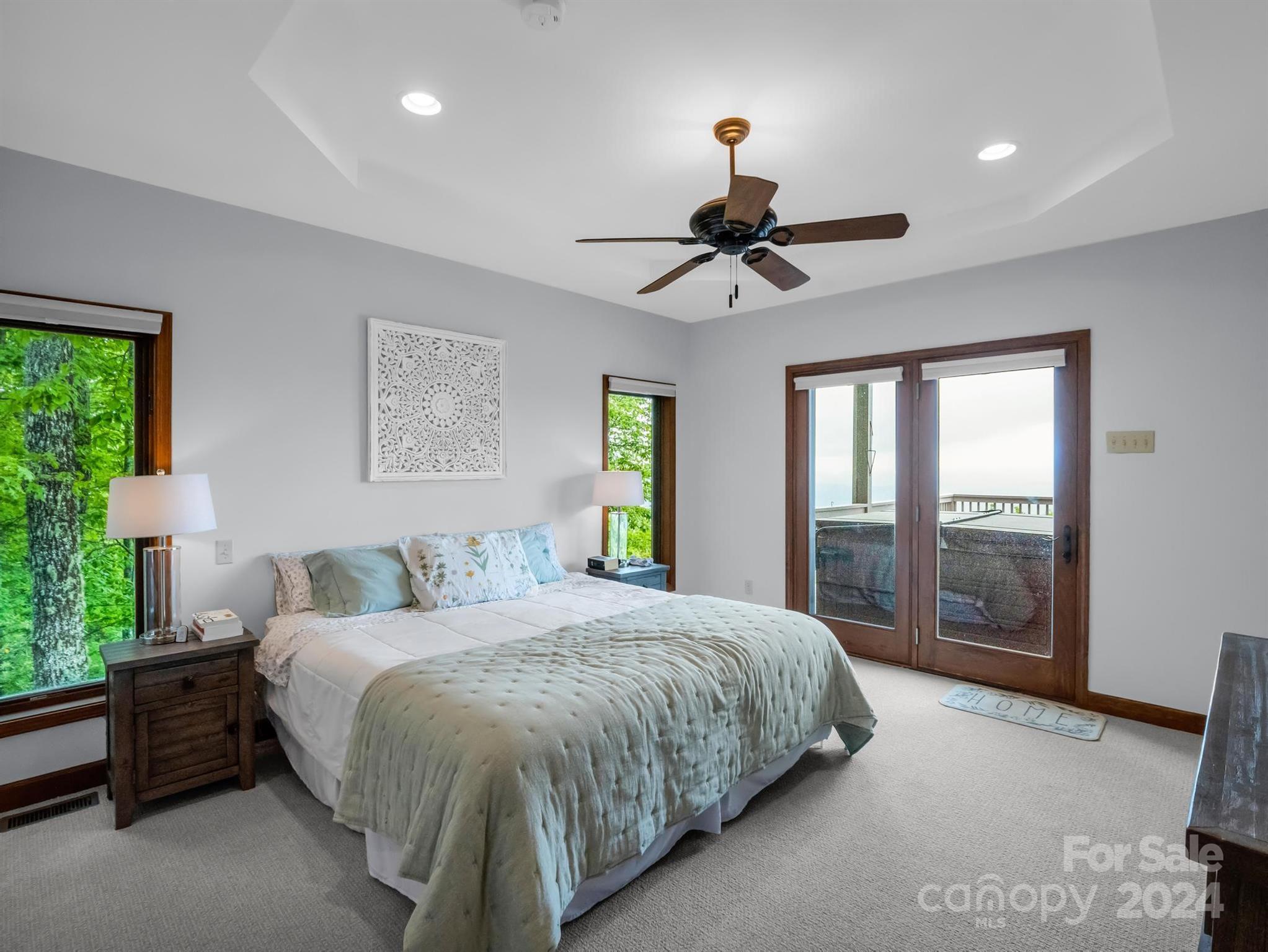 428 Devils Hole Road, Unit 14 Rosman, NC 28772 - Photo 20 of 47 a bedroom with a large bed and a chandelier