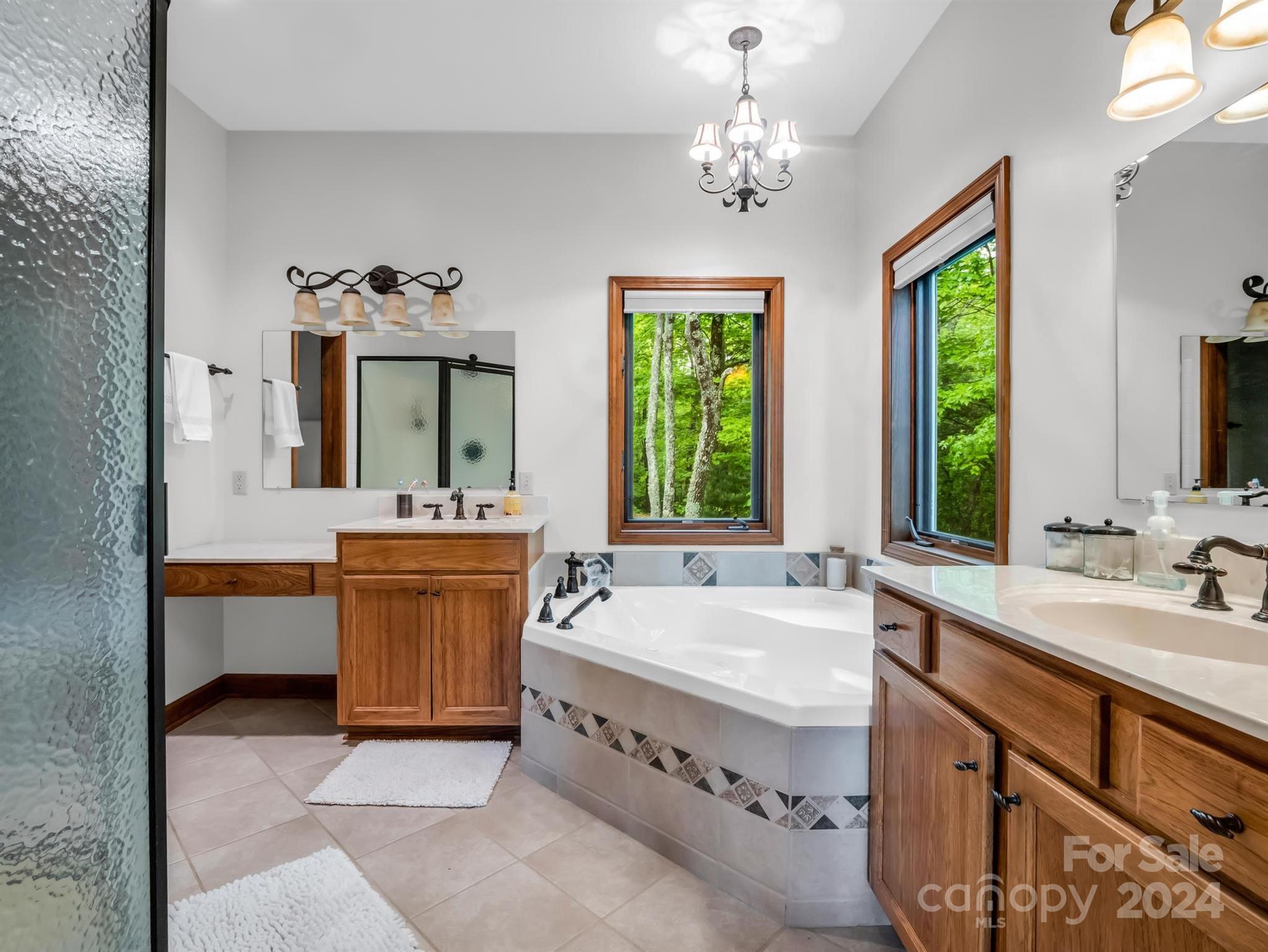 428 Devils Hole Road, Unit 14 Rosman, NC 28772 - Photo 23 of 47 a spacious en suite bathroom with a granite countertop tub sink and mirror